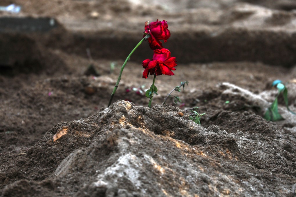 Relatives plant roses on the graves of Covid-19 victims at the Bada Qabrastan graveyard, in Mumbai, India. Photo: EPA-EFE