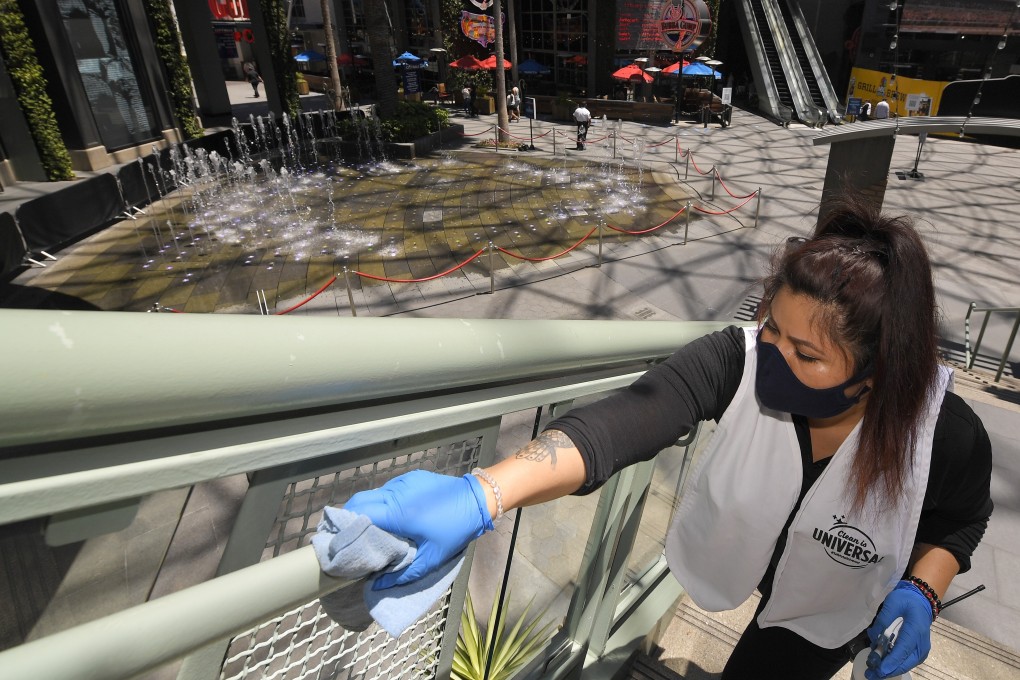 A woman cleans the railings at Universal CityWalk near Universal City, California. Photo: AP Photo