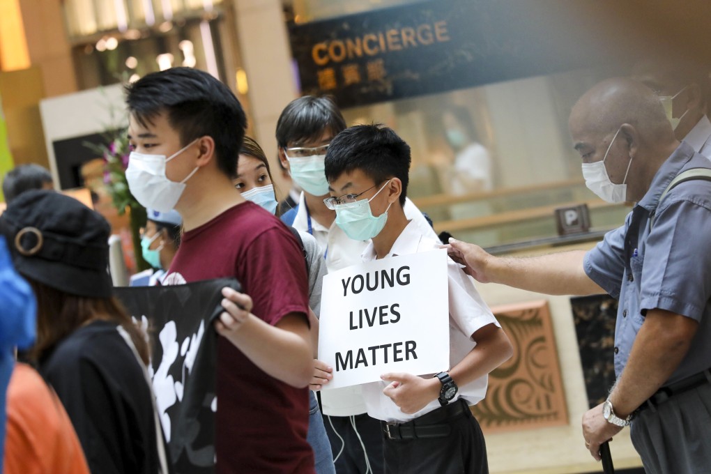 A teenager carries a placard saying “Young lives matter” at a lunchtime protest at the Landmark shopping centre in Central, Hong Kong. Photo: K.Y. Cheng