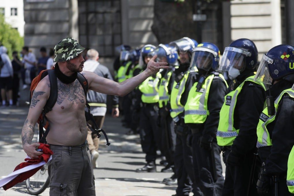 A far-right protester gestures towards police officers at Trafalgar Square in London. Photo: AP