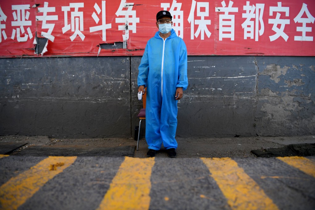 A security guard wearing a protective mask and suit stands at a checkpoint outside Xinfadi market in Beijing, which has been linked to a new cluster of coronavirus cases. Photo: AFP