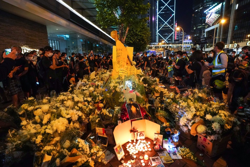 Mourners at Pacific Place mall offer flowers at a shrine. Photo: Felix Wong
