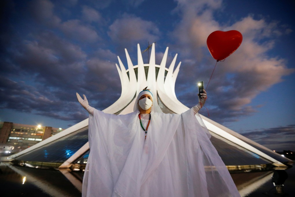 An artist performs with a red balloon in Brasilia, Brazil on Monday during a protest to honour people who died of Covid-19. Photo: Reuters