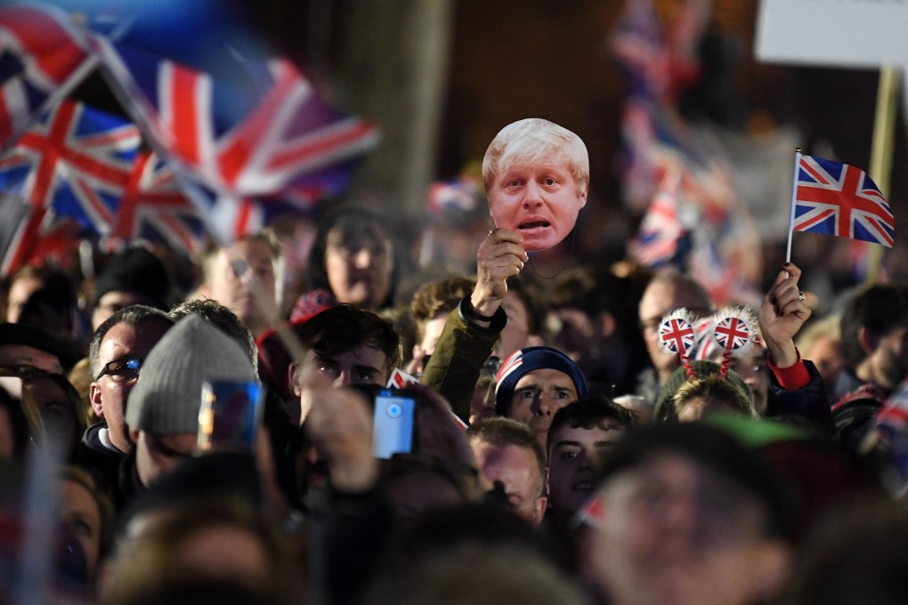Brexit supporters wave Union flags and a mask of Britain’s Prime Minister Boris Johnson in Parliament Square on January 31, to celebrate the moment that Britain formally leaves the European Union. Photo: AFP