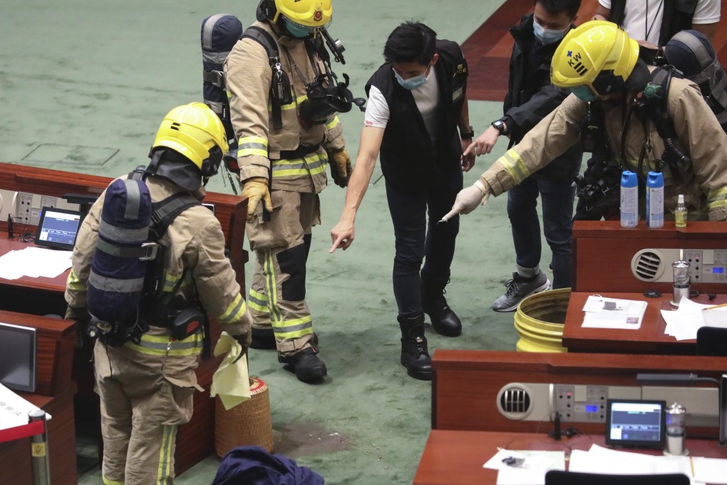 Firefighters and police officers check the chamber of Hong Kong’s Legislative Council after opposition lawmakers hurled stinky objects during a debate on the national anthem bill on June 4. Photo: K.Y. Cheng