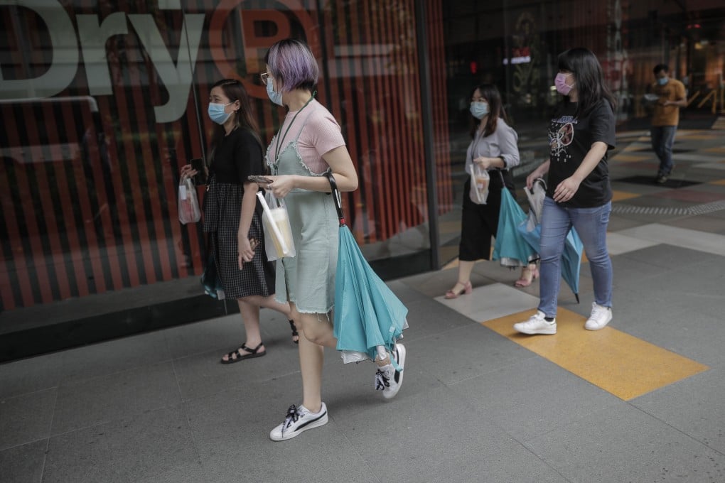 People carrying takeaway food exit the Funan shopping centre in Singapore on Tuesday. Photo: EPA