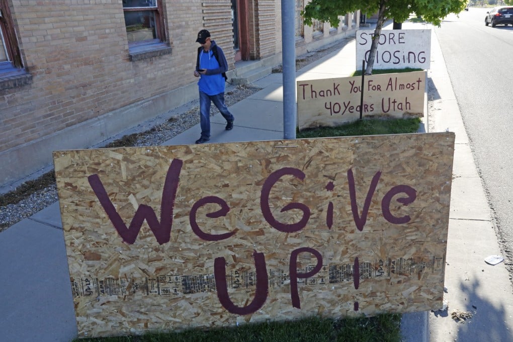 Signs outside an art and antique shop closing down in Salt Lake City on May 8. Millions without jobs also lose health insurance as Covid-19 widens inequalities in the US. Photo: AP