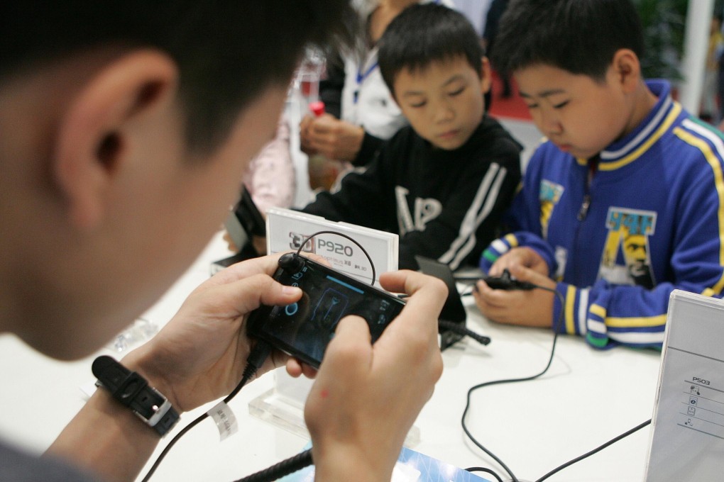 Chinese kids play mobile games on smartphones during an expo in Chengdu city, Sichuan province, on 20 October 2011. Photo: Imaginechina