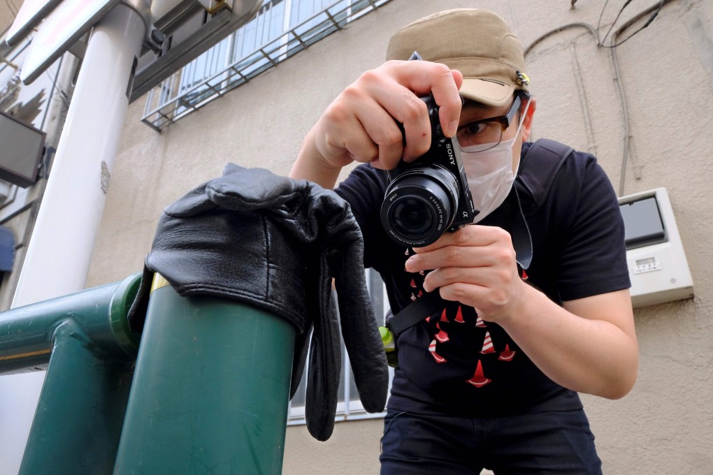 Japanese photographer Koji Ishii takes pictures of a lost glove in Tokyo. Photo: AFP