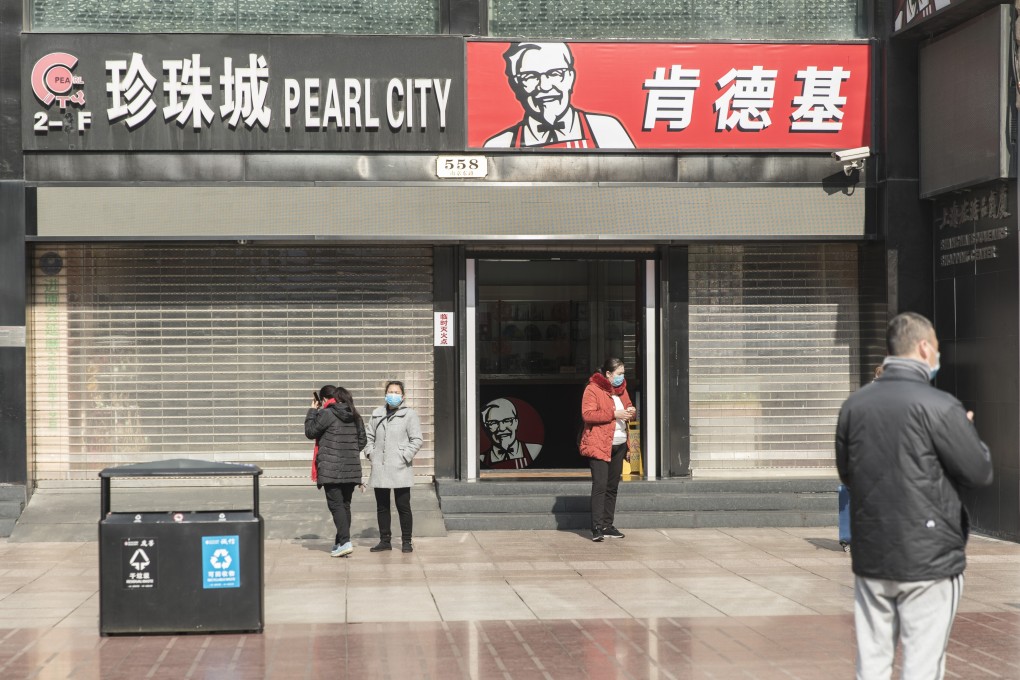 Pedestrians wearing protective masks stand in front of KFC restaurant on Nanjing Road in Shanghai, China, on February 5. Photo: Bloomberg