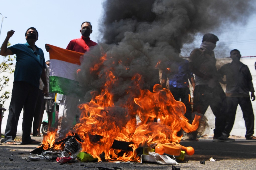 Anti-China protesters hold the Indian national flag as they burn Chinese products during a demonstration in New Delhi on June 18. Photo: AFP