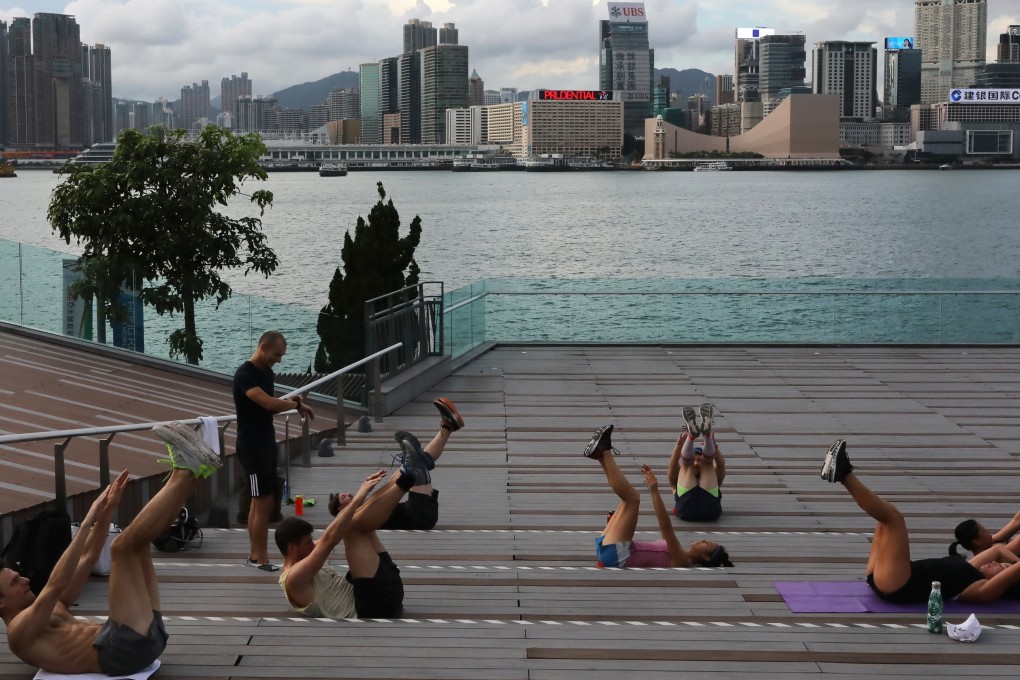 A group of people exercising together at Tamar Park, Admiralty, Hong Kong during the coronavirus pandemic. It has shaken up people’s routines, brought family members closer together, and fostered the practise of mindfulness, experts observe. Photo: K.Y. Cheng