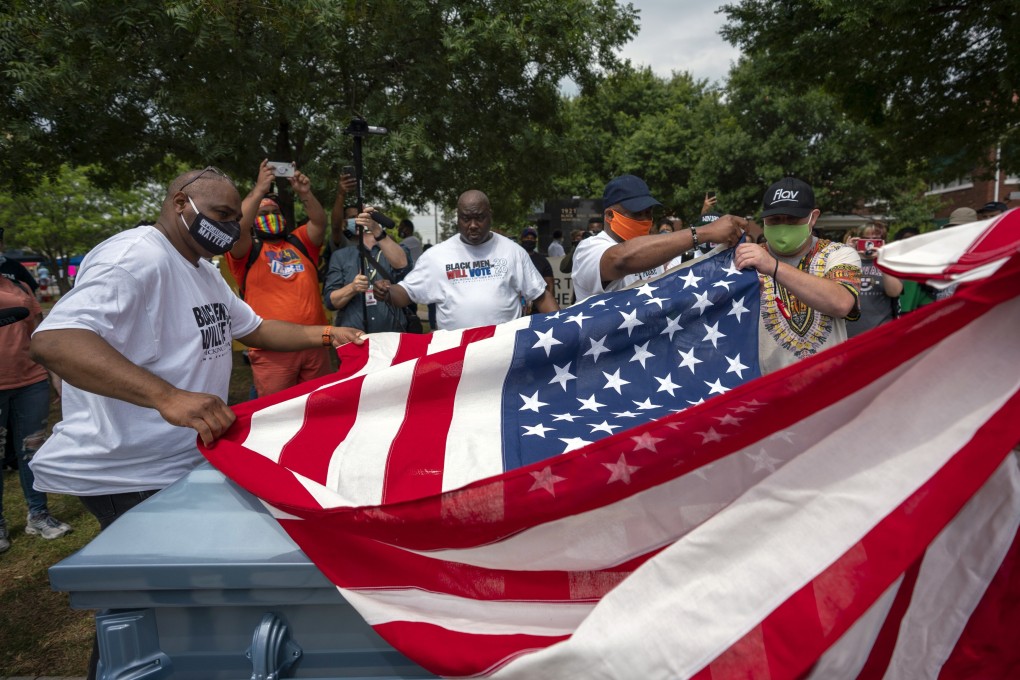 People fold an American flag near an empty casket during a Juneteenth celebration in Tulsa, Oklahoma. Photo: Bloomberg