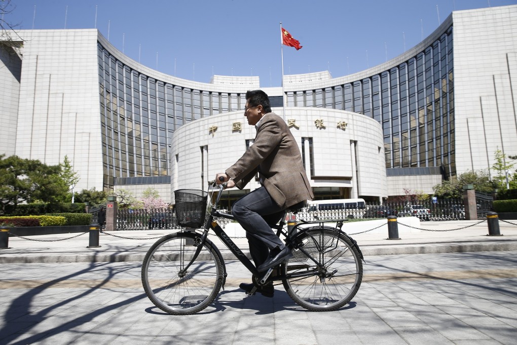 A cyclist rides past the headquarters and head office of the People's Bank of China (PBOC) in Beijing on 16 April 2015. Photo: Imaginechina