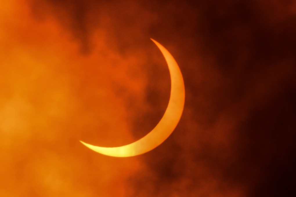 The moon moves in front of the sun during an annular solar eclipse as seen in New Delhi. Photo: AFP