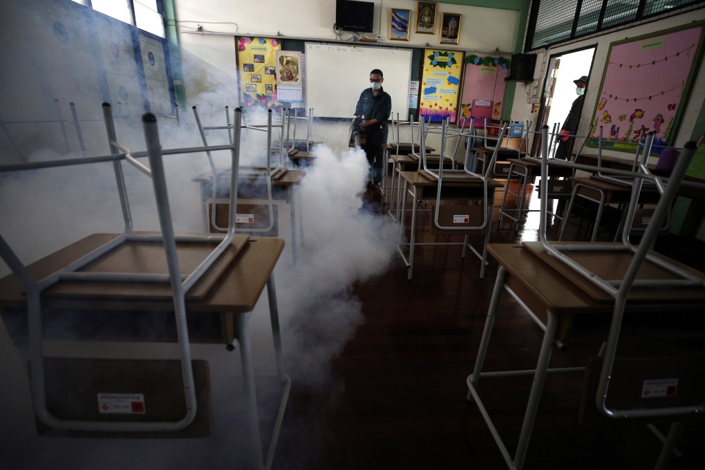 A health officials sprays chemicals to kill mosquitoes inside a classroom of a school in Bangkok, Thailand, earlier this month. Photo: EPA