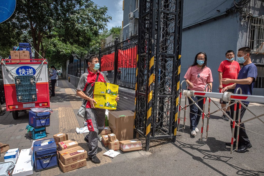 A courier delivers packages for residents prevented from leaving their compound in northern Beijing because of coronavirus restrictions. Photo: EPA-EFE
