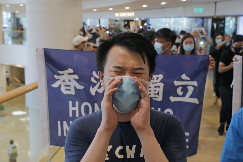 Protesters shout slogans and hold flags in a shopping centre during a protest in Hong Kong earlier this month. Photo: AP