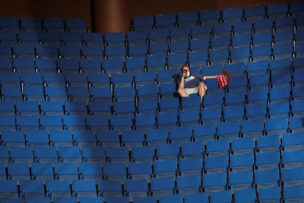 A supporter of US President Donald Trump shoots a video with his mobile phone from the sparsely filled upper decks of the arena. Photo: Reuters