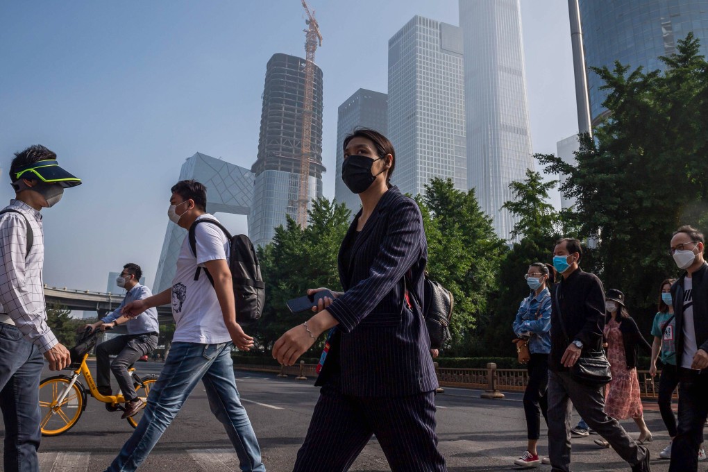 People commute during the morning rush hour before the opening session of the National People's Congress (NPC) in Beijing on May 22, 2020. – China took the rare move of not setting an annual growth target this year after the coronavirus battered the world's second-largest economy and ravaged global growth, Premier Li Keqiang said on May 22. (Photo by NICOLAS ASFOURI / AFP)