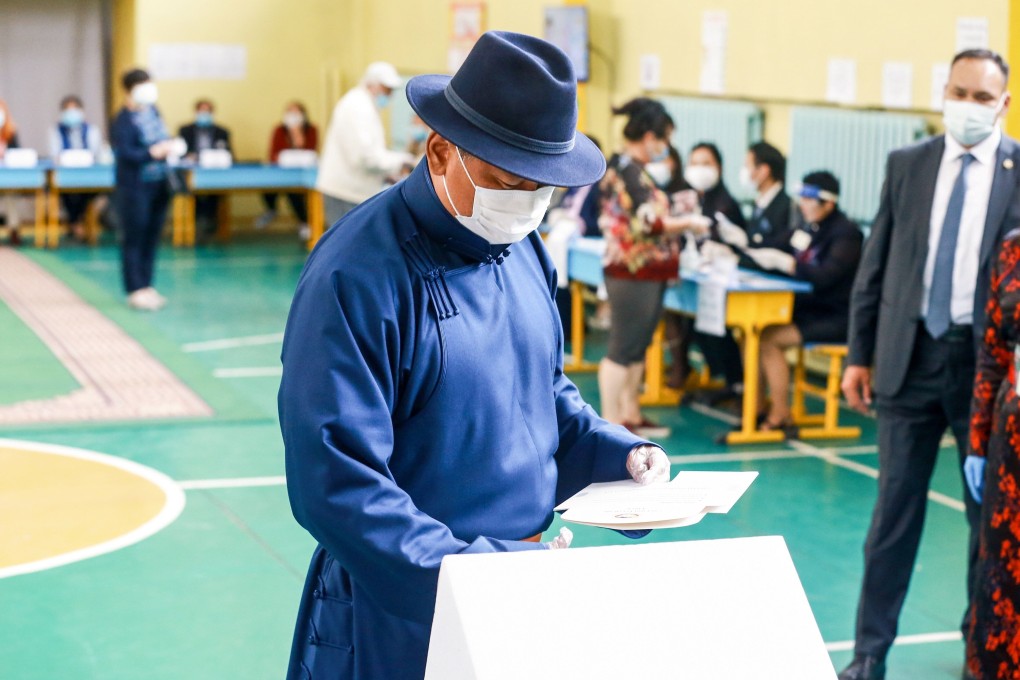 Mongolia's Prime Minister Ukhnaagiin Khurelsukh wears a face mask as he votes at a polling site in Ulan Bator on Wednesday. Photo: AFP