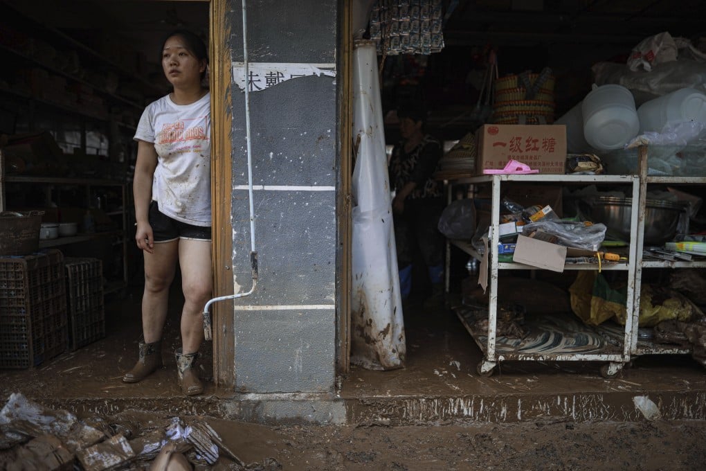 A woman looks out from her flooded home in Guizhou province. Photo: Xinhua