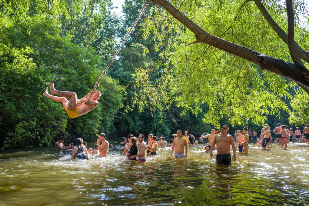 Sunseekers cool off in a river in London on June 24. Photo: AFP