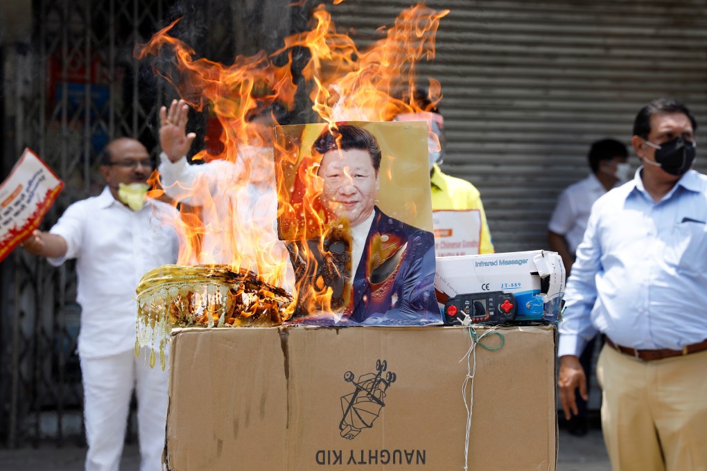 Protesters burn products made in China and a defaced poster of Chinese President Xi Jinping in New Delhi on June 22. Photo: Reuters