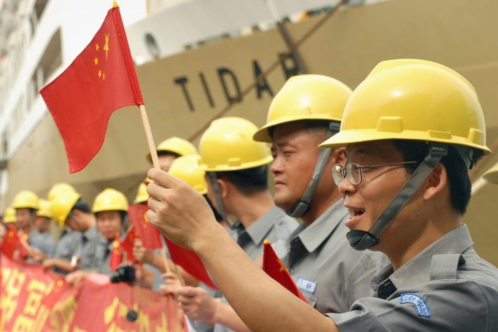 Workers wave Chinese flags during China Vice-Premier Li Keqiang’s visit to the Suramadu bridge in Surabaya, East Java, on December 21, 2008. File photo: AFP