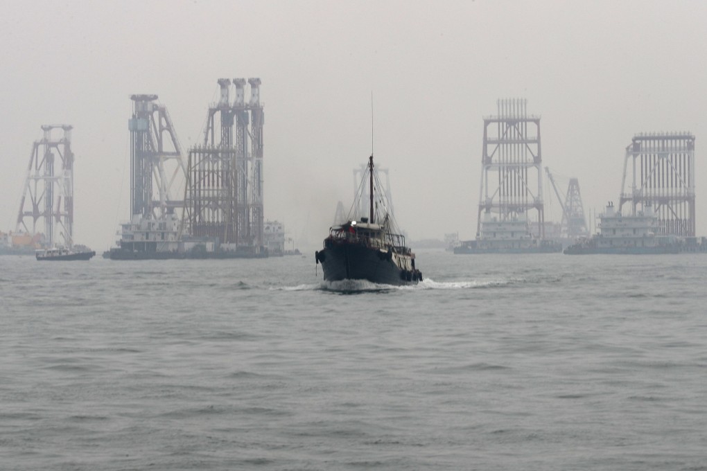 A boat heads away from construction work as part of the third runway at Hong Kong International Airport on August 20, 2018. Uncertainty over the future of the aviation industry and potential cost overruns raise questions about the need for the project. Photo: Nora Tam