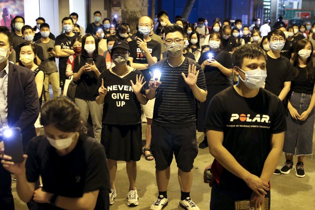Protesters turn on the flashlight of their mobile phones as they mark the first anniversary of the anti-government movement and show their opposition to the incoming national security law for Hong Kong, at Yuen Long MTR station on June 12. Photo: Edmond So