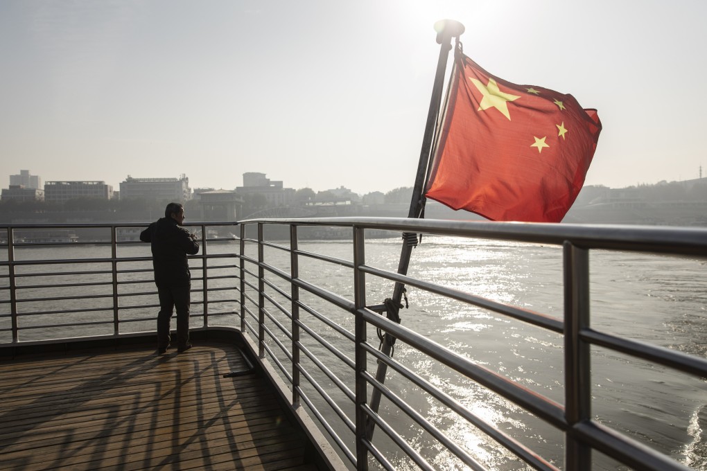A Chinese national flag flies on the deck of a ferry crossing the Yangtze River in Wuhan, China in December 2019. Investors are speeding up their M&A deals in China this year while Chinese investors pull back from overseas market. Photo Handout
