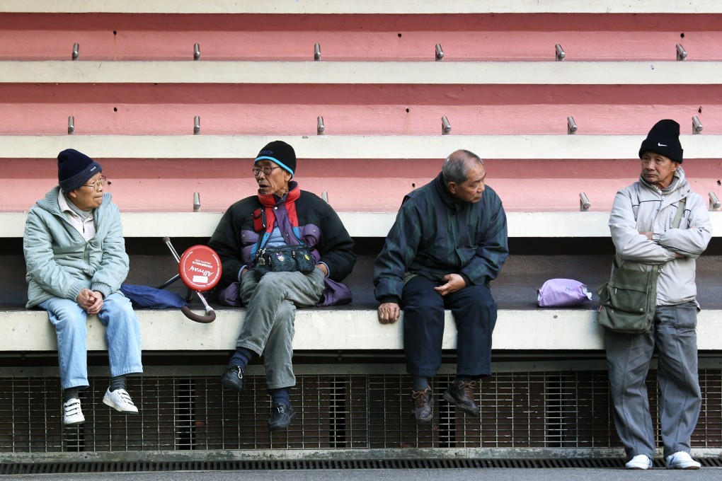 Elderly people gather near the football terraces at Southorn Playground in Wan Chai on January 14, 2014. The dividers on the terraces appear to be placed to prevent homeless people from sleeping there. Photo: SCMP