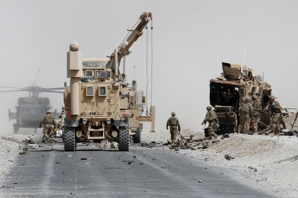 US troops assess the damage to an armoured vehicle of NATO-led military coalition after a suicide attack in Kandahar province, Afghanistan. Photo: Reuters