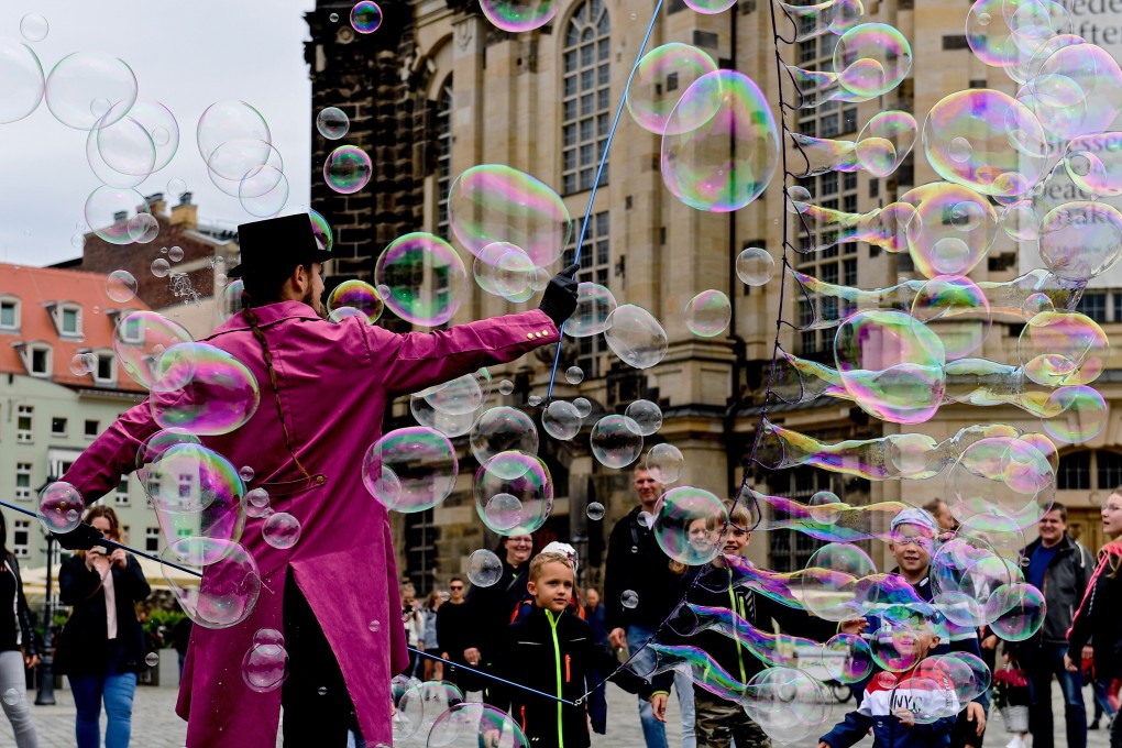 A street artist makes giant soap bubbles on Neumarkt square in Dresden, Germany, on May 31 as tourism restarts with the easing of lockdowns. Photo: EPA-EFE