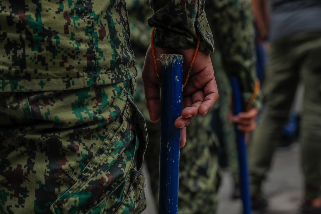 A Philippine police officer holds a baton. Police arrested a German man on suspicion of killing his Filipino wife. Photo: EPA-EFE