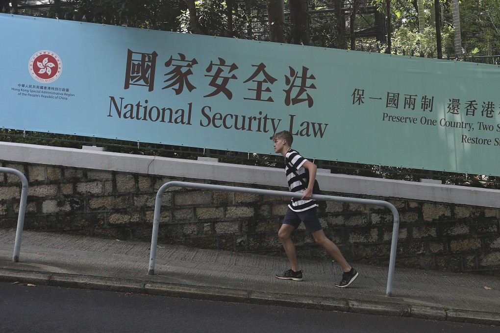 A man walks up a road where a banner promoting the national security law is displayed in Central, Hong Kong, on June 20. Photo: Jonathan Wong