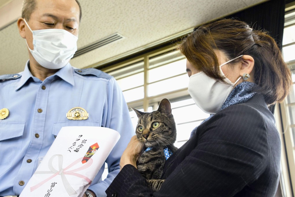Tomoko Nitta and her cat Koko receive an award at a police station in Toyama. Photo: Kyodo