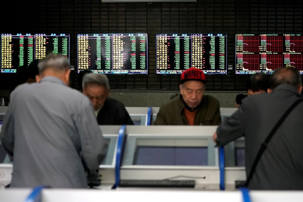 Investors look at computer screens showing stock information at a brokerage house in Shanghai. Photo: Reuters