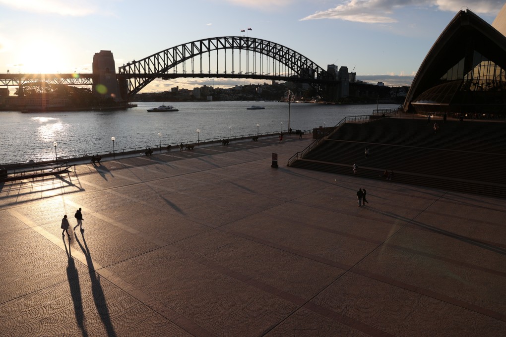 People are seen walking in front of the Sydney Opera House and Sydney Harbour Bridge earlier this month. Photo: Reuters