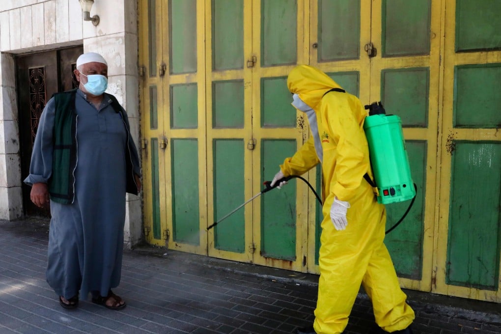 A health department worker of the Palestinian Hebron Municipality sterilises a street. Photo: AFP
