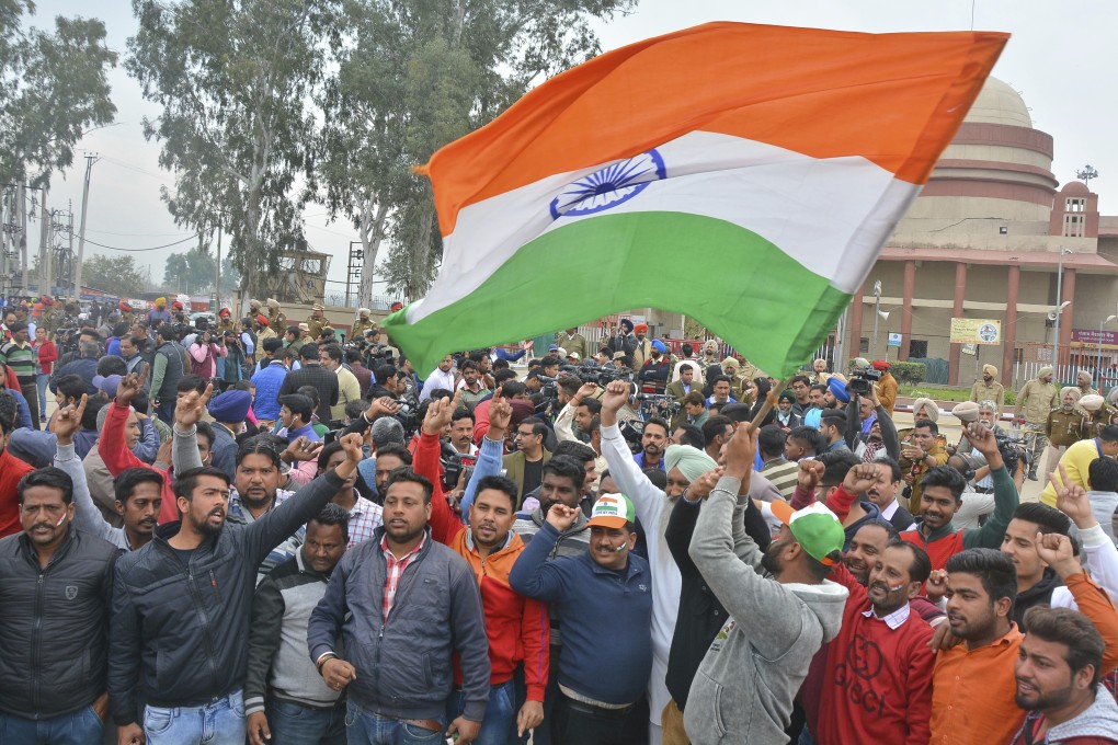 An Indian man waves the national flag at Wagah, near the border with Pakistan. India’s relations with its neighbours have deteriorated, as it is increasingly perceived as a regional bully. Photo: AP
