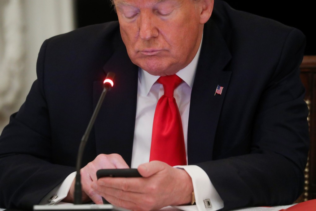 US President Donald Trump uses a mobile phone during a round-table discussion at the White House. Photo: Reuters
