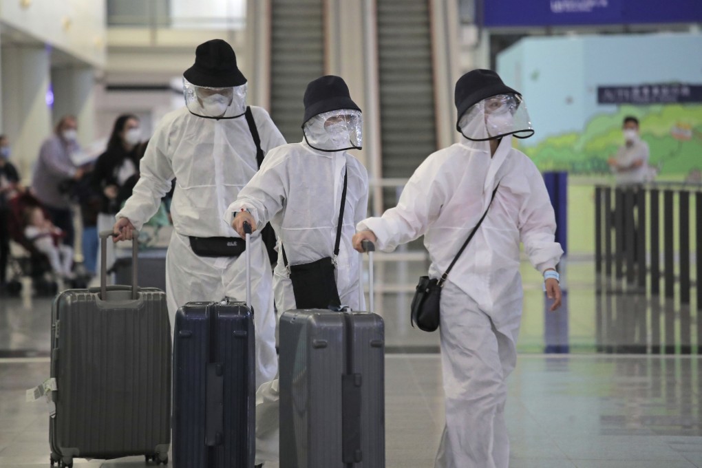 Passengers wearing protective gear arrive at the Hong Kong airport on March 23. As Hong Kong began to record an increasing number of imported Covid-19 cases, all incoming travellers were required to undergo testing at a centre set up at AsiaWorld-Expo. Photo: AP