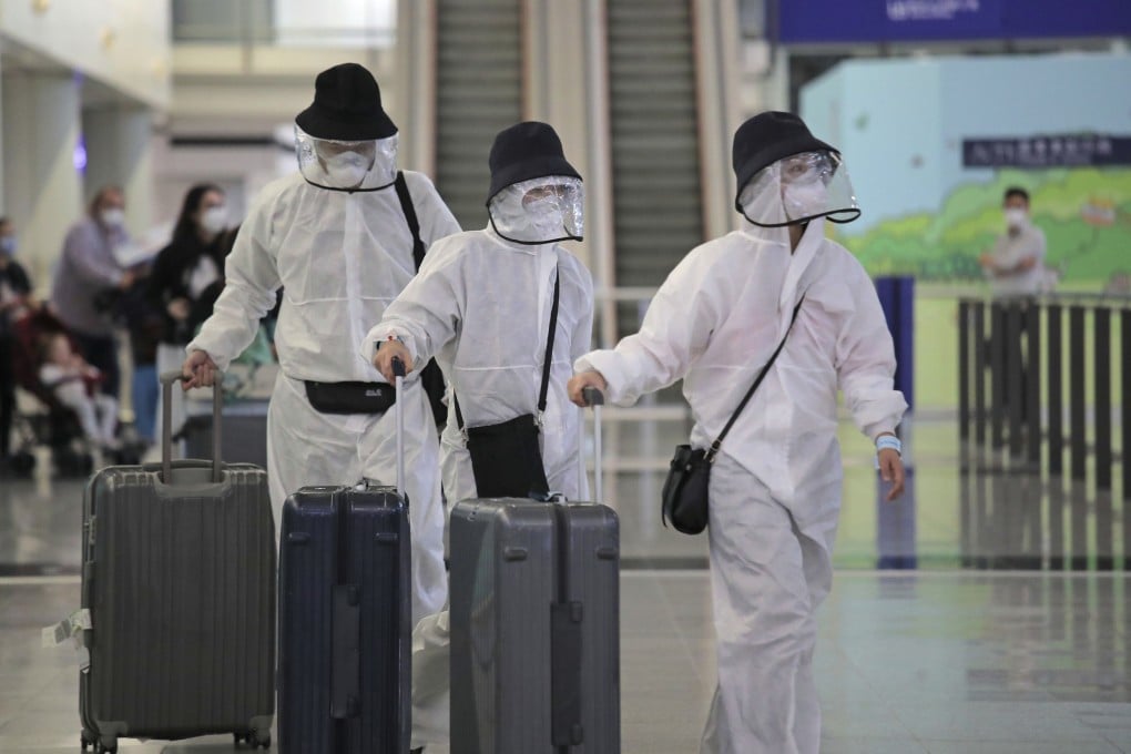Passengers wearing protective gear arrive at the Hong Kong airport on March 23. As Hong Kong began to record an increasing number of imported Covid-19 cases, all incoming travellers were required to undergo testing at a centre set up at AsiaWorld-Expo. Photo: AP
