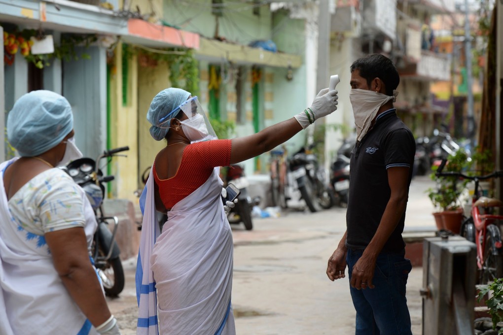 A health worker checks the temperature of a resident outside a containment zone in Hyderabad, India, on Tuesday. India’s economy is set to contract by 4.5 per cent this year due the Covid-19 pandemic. Photo: AFP