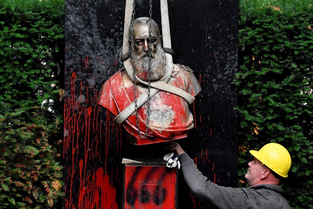 A worker helps to remove the vandalised statue of King Leopold II in Ghent, Belgium on Tuesday. Photo: AFP
