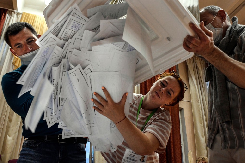 Members of a local electoral commission empty a ballot box at a polling station in Moscow on Wednesday. Photo: AFP