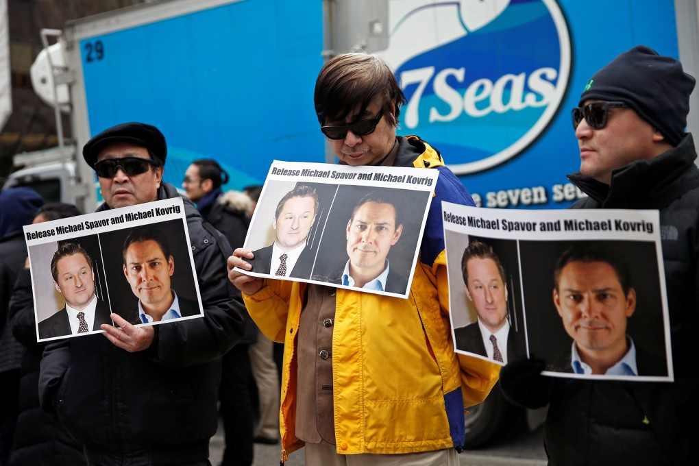 People hold placards calling for China to release Canadian detainees Michael Spavor and Michael Kovrig outside a court hearing for Huawei executive Meng Wanzhou in Vancouver, British Columbia, Canada, in March 2019. Photo: Reuters