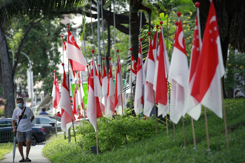 A man walks past Singapore national flags in a residential area ahead of the general election in Singapore. photo: EPA
